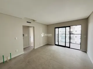 Espaço interno de uma sala com paredes brancas e piso de concreto.
