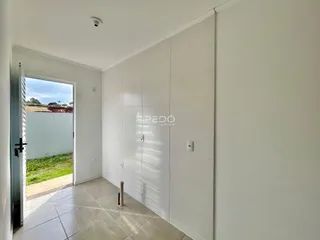 Interior de um ambiente com piso de cerâmica e parede branca.