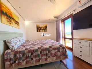 Quarto com cama e piso de madeira.
