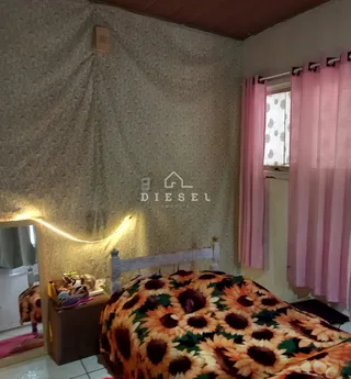 Quarto com cama coberta e cortinas rosa.