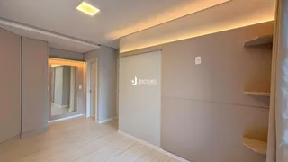 Interior de uma sala de estar com piso de madeira clara e paredes neutras.