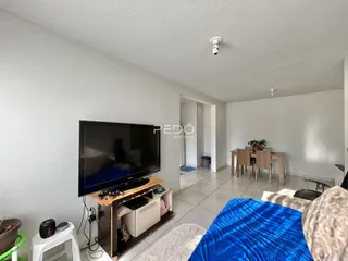 Sala de estar com televisão e sofá em um imóvel no Brasil.