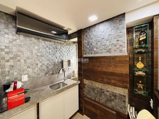 Cozinha moderna com revestimento de pedra e armários de madeira escura.