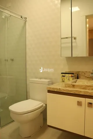 Foto de um banheiro interno com vaso sanitário e box de vidro.