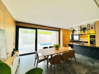 Sala de jantar com acesso a uma área externa com piscina.