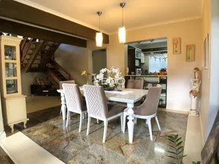 Vista da sala de jantar com mesa e cadeiras em um imóvel no Brasil.