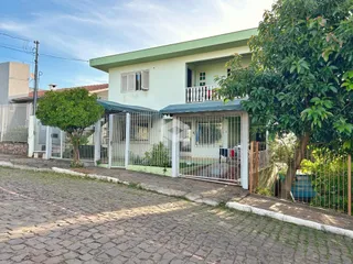 A fachada de uma casa em Lajeado, Brasil, com cerca e vegetação.