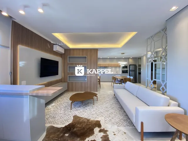 Sala de estar moderna com sofá branco e painel de madeira.