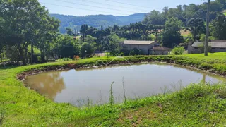 Vista externa mostrando um lago e vegetação exuberante em uma área verde.