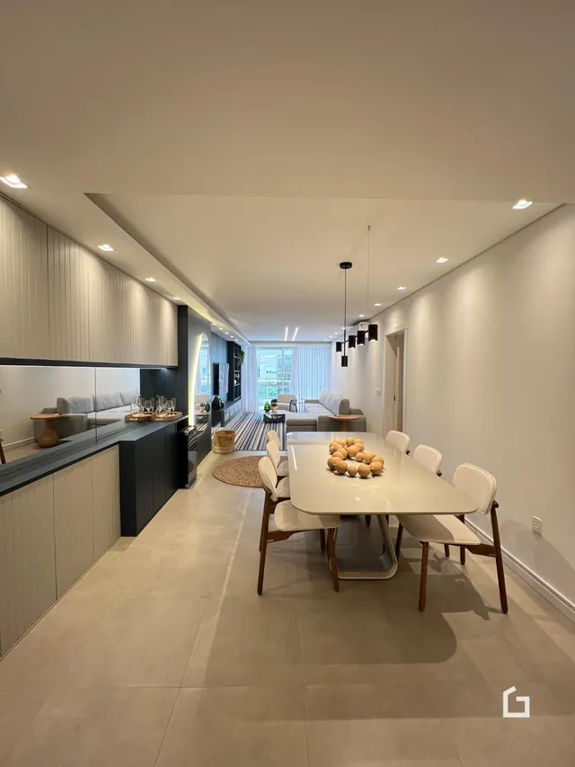 Ambiente moderno de sala de estar e jantar com piso claro.