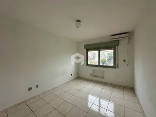 Ambiente interno de uma sala com piso de cerâmica clara e janela.