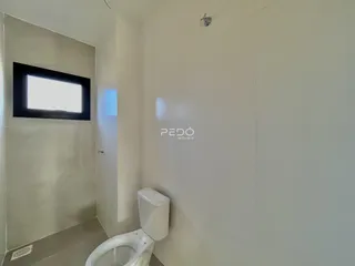 Foto de um ambiente interno com paredes brancas e um vaso sanitário.
