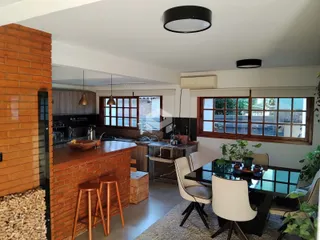Foto de uma cozinha aberta com bancada e mesa de jantar em um imóvel.
