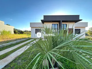 Fachada moderna de uma casa em Lajeado com jardim na frente.