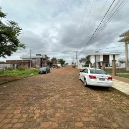 Vista da entrada de uma propriedade em Lajeado, Brasil, mostrando uma área pavimentada e um carro estacionado.