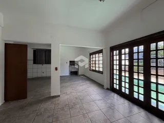 Interior de uma área comum com piso de cerâmica e portas de madeira.