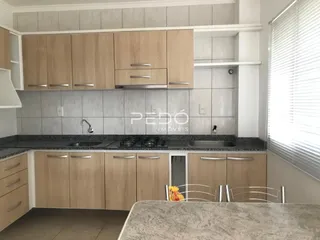 Foto de uma cozinha com armários de madeira clara e revestimento cinza.