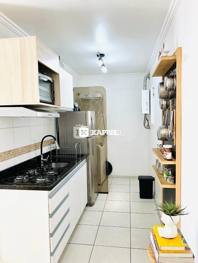Foto de uma cozinha com armários brancos e piso de cerâmica.