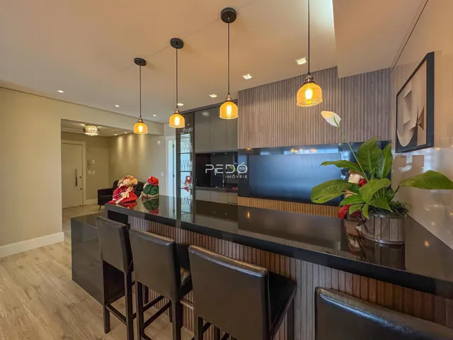 Ambiente moderno com bancada e sala de jantar em imóvel no Brasil.