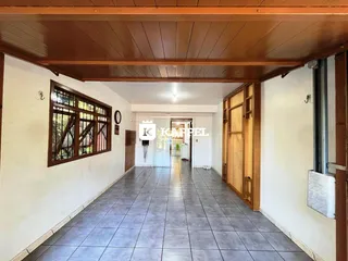 Corredor interno com piso de cerâmica e portas de madeira.