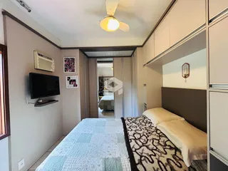 Quarto com cama e armários em um apartamento em Lajeado.