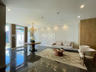 Sala de estar com piso de mármore escuro e sofá claro.