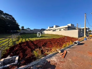 Vista externa de uma propriedade com cerca e terreno adjacente.