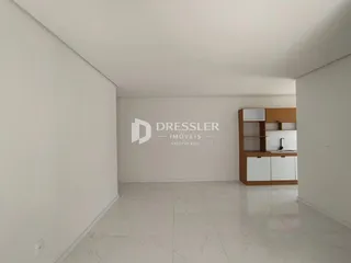 A foto mostra um corredor amplo com piso de porcelanato claro.