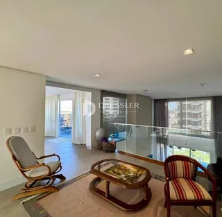 Sala de estar com piso de madeira e vista para o exterior.