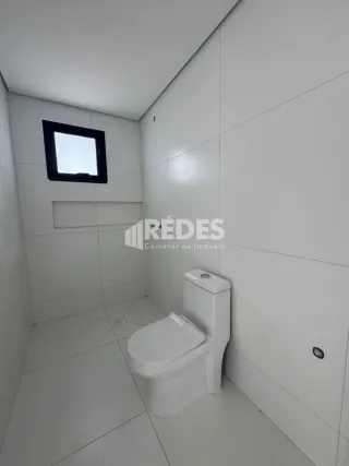 Foto de um banheiro interno com paredes e piso brancos.