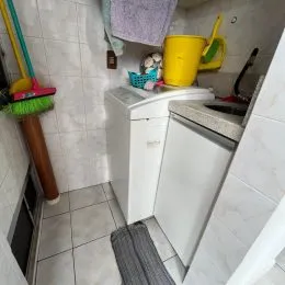 Vista de um canto de um ambiente interno com revestimento de azulejos brancos.