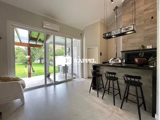 Sala de estar com portas de vidro que dão acesso a um jardim.