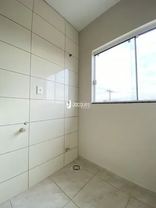 Parede interna com revestimento cerâmico e janela em um imóvel.