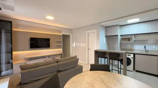 Sala de estar moderna com sofá e televisão em um apartamento.