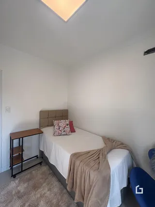 Foto de um quarto com cama e paredes brancas.