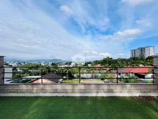 Vista panorâmica de uma propriedade com paisagem e edifícios ao fundo.