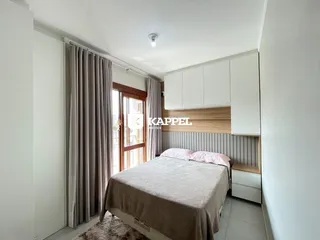 Quarto com cama e armários brancos em um apartamento.