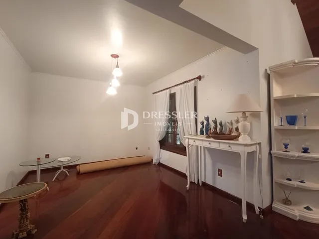 Sala de estar com piso de madeira escura e paredes brancas.