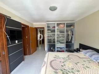 Quarto com cabeceira e armário de madeira em um imóvel no Brasil.