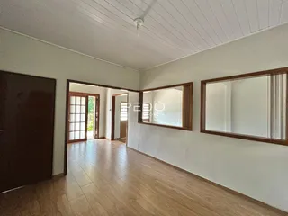 Hall de entrada com piso de madeira e portas de vidro.