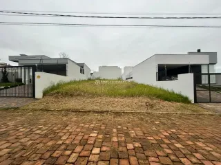 Fachada de uma residência branca com paisagismo em Lajeado.