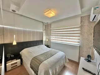 Quarto com cama e janela em ambiente interno.