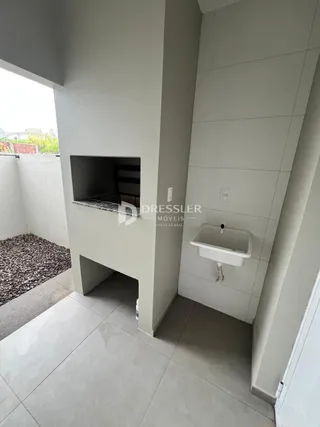 Interior de um ambiente com paredes brancas e piso de cerâmica.