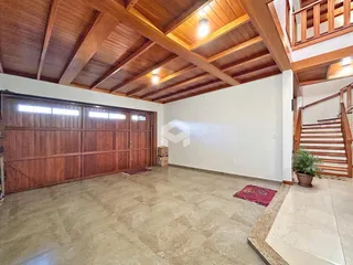 Imagem de uma área interna com teto de madeira e piso de cerâmica.