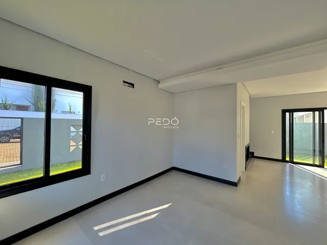 Interior de uma sala com paredes brancas e piso claro.