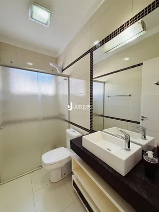 Foto de um banheiro moderno com azulejos e bancadas brancas.