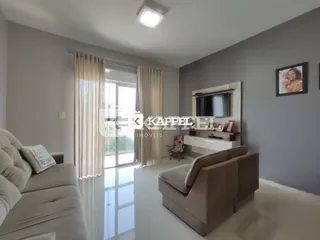 Sala de estar com sofá e janela de grande porte em um apartamento.