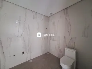 Foto de um banheiro com paredes revestidas em mármore branco.