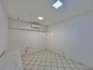 Ambiente interno de uma sala com piso de cerâmica e teto branco.