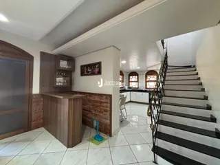 Interior de uma sala de estar com acesso a uma escadaria em um imóvel em Lajeado.